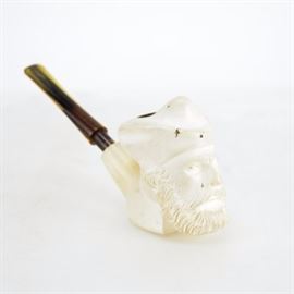 Carved Meersham Pipe: A carved meerschaum pipe. This tobacco pipe features a meerschaum bowl carved into the shape of the head of a man with a screw on plastic pipe stem. The pipe bears no manufacturer markings.