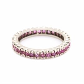 14K White Gold Ruby Eternity Band: A 14K white gold ruby eternity band. This band features thirty-two round faceted rubies held in a fishtail setting.