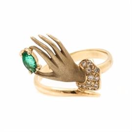 14K Yellow Gold Emerald and Diamond Hand Motif Ring: A 14K yellow gold emerald and diamond hand motif ring. This ring features a satin hand motif, wearing a diamond accented cuff, holding an emerald.