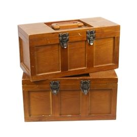 Wooden Storage Cases: A pair of wooden storage cases for tools or craft supplies. Each rectangular case features a top wooden handle and a double latch to the front. The interior includes a pull out tray.