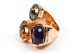 Rebecca Italian Designer Multi Stone Ring: A Rebecca rose gold-tone costume cocktail ring with large, colorful synthetic gemstones. The ring has a very large setting with large purple, green and yellow checkerboard-cut stones in bezel settings.