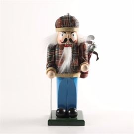 Decorative Nutcracker Doll: A decorative nutcracker doll. This doll depicts a golfer wearing a plaid hat, plaid shirt, blue pants, and black shoes. The figure is holding a golf club and has a golf bag over one shoulder. The piece is marked on the bottom with stickers which read “Made in China” and “Target”.