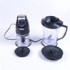 Ninja Food Processor/Blender: A Ninja food processor and blender. This all-in-one piece is equipped for mixing food and drinks. It features a master pod and two clear plastic pitchers.