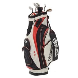 TaylorMade Golf Clubs with Bag: A group of TaylorMade golf clubs plus one with a golf bag. The TaylorMade putter is a Nubbins, it comes with a head cover. The other TaylorMade clubs are RAC irons include: 4, 5, 6, 7, 8, and a 9. The “plus one” is a Titleist “Oil Can 8620” “BV 258•08 Vokey Design”. The canvas bag is a TaylorMade red, white and black.