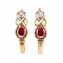 14K Yellow Gold Ruby and Diamond Hoop Earrings: A pair of 14K yellow gold ruby and diamond hoop earrings. These earrings feature prong set, faceted pear rubies in a knot design that leads to a white gold accent containing a single diamond in each earring.