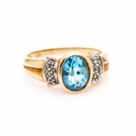 14K Yellow Gold Topaz and Diamond Ring: A 14K yellow gold topaz and diamond ring. This ring showcases a topaz center, accented by six diamonds adorned to the top of the flared and ridged shoulders. The total carat weight of all diamonds included is 0.05 ctw.