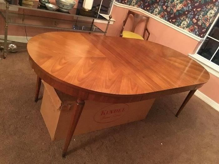 Kindel Oval Table- Top is four pieced matched veneer fruitwood Top closed: 42 x 52. Top open: 42 x 100 (3-16" leaves with apron with original storage box underneath)