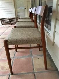 Set of 4 Danish Modern chairs all in a row.