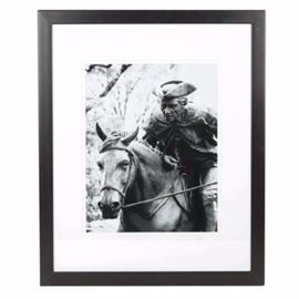 Robert Yaeger Photograph "The Spirit of Mecklenburg": A framed black and white photograph by noted Charlotte artist, painter, and photographer Robert Yaeger titled The Spirit of Mecklenburg. This original image depicts Captain James Jack on horseback as he delivers his county’s declaration of independence to the Continental Congress in 1775 in Philadelphia, Pennsylvania. The print is presented with white matting and housed in a black frame. To learn more about Yaeger and view his work, please see the link below.