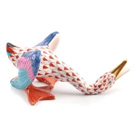 Herend Hungary "Honking Goose" Figurine: A hand painted fine porcelain Honking Goose figurine from Hungarian maker Herend. The bird is handcrafted from fine porcelain and is decorated with the traditional fishnet pattern in rust on a white background with 24K gold detailing and blue and bright pink feathers to the wings. He is depicted with his neck stretched downward and his beak open. Marked “Herend Hungary Handpainted”.