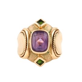 14K Yellow Gold Amethyst and Green Tourmaline Statement Ring: A 14K yellow gold ring inspired by Renaissance style. This piece offers broad, rounded shoulders meeting an equally broad center enhanced with a bezel set amethyst feature stone and two green tourmaline accent stones.