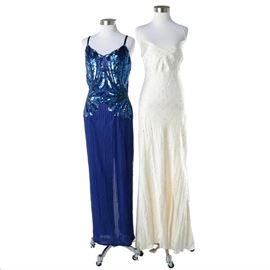 Embellished Full-Length Formal Gowns Including DKNY: A selection of women’s embellished full-length formal gowns. The selection includes an acetate and rayon gown in ivory with spaghetti straps, a scooping V-neckline, a fitted waist and hip, a flowing skirt and criss-cross back straps, all accented by white rhinestones throughout by DKNY. Also included is a blue silk grown featuring heavily beaded straps, bodice, hip and a beaded stripe column skirt with a center back skirt slit by Stenay.