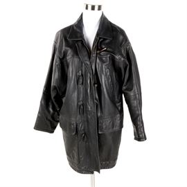 Women's Burberry Black Leather Toggle Coat: A women’s Burberry black leather coat. This piece features toggle and zipper closures, a slash pocket to the left chest, two flap pockets, an interior pocket and is lined in Burberry’s classic plaid. It is labeled to the interior, “Burberry made in England”.