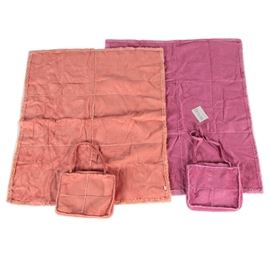 Faux Shearling Throws with Tote Bag: A pair of faux shearling throws with tote bag by Snug.The pair features a pink and an orange Snug faux shearling throws with matching tote bags with cross stitch detailing on seams. The tote bags have zipper closures and shoulder straps.