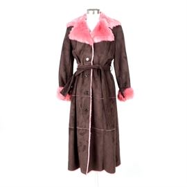 Women's Terry Lewis Brown and Pink Faux Fur Over Coat: A women’s Terry Lewis brown and pink faux fur over coat. This coat has a bright pink notched collar, a brown faux suede body and bright pink faux fur cuffs. The floor length coat has a front button closure, a belted waist and a bright pink faux fur lining. A black “Terry Lewis Classic Luxuries” label and retail tags are present.