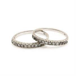 10K White Gold Diamond Rings: A pair of 10K white gold 0.63 ctw diamond rings. These rings feature a row of prong set, single cut diamonds that lead to the straight