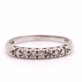 Platinum and Diamond Band: A platinum and diamond band. This band features a row of seven diamonds set in platinum. A ring box is included.