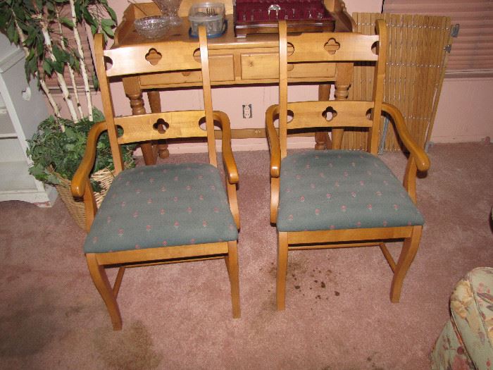 A pair of wooden chairs, upholstered in blue.