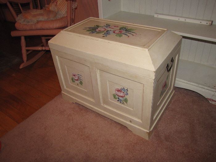A small, white blanket chest.  
