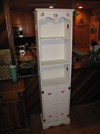 A tall, white painted shelf unit.