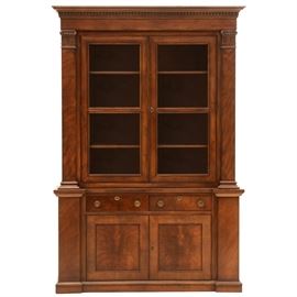 Drexel Heritage Cabinet: A Drexel Heritage cabinet from their Covington Park Collection. Of mixed hardwood construction with walnut veneers. Having dentil molding to top over two glass fronted doors with lighted display shelves behind them flanked by pilasters, two drawers, and two solid doors with a fiddle back style wood pattern concealing a space divided into four compartments, each side with an adjustable shelf. The display doors and cabinet doors are accessed with a key while the drawers boast stylized round aged copper pulls.