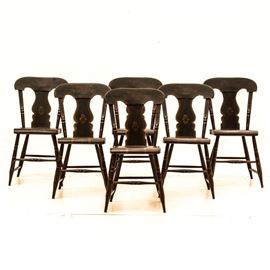 Set of Six Hitchcock Style Side Chairs: A set of six Hitchcock style side chairs. These antique, hand painted chairs have a black finish with a subtle floral motif to the the top rail and back splat, with gold detailing throughout. Each chair is designed with an urn-shaped back splat, slightly curved seat and rises on turned, tapered legs with an H stretcher.