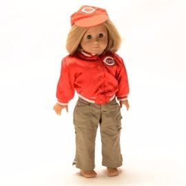 American Girl Historical Doll Kit Kittredge: An American Girl doll from the Historical dolls series, Kit Kittredge. Kit is a light skin doll with freckles dark blue eyes and short bobbed blonde hair . She is dressed in a tagged American Girl Cincinnati Reds jacket and hat with a pair of khaki pants.