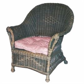 Wicker Armchair: A wicker armchair. This chair features a green paint finish wicker frame with curved crest rail and armrests flanking a seat over a deep apron rising on round feet. The chair includes a button tufted cushion. There are no visible maker’s marks.