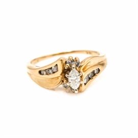 14K Yellow Gold Diamond Ring: A 14K yellow gold 0.33 ctw diamond ring. This ring features a marquise cut diamond in the center that is offset by two diamonds each at the top and bottom. The arms of the criss cross setting feature additional diamonds.