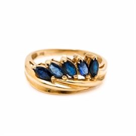 14K Yellow Gold Sapphire Ring: A 14K yellow gold sapphire ring. This criss cross setting features a crown of marquise cut sapphires set in a row at an angle.