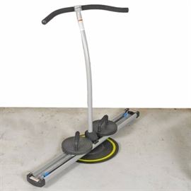 Fitness Quest Stride Trainer: A Fitness Quest stride trainer. This item features a long horizontal base with two footholds and an elevated handle to help with stability while using the equipment. This piece has a Fitness Quest tag towards the bottom.