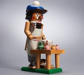 Offered is a vintage 15" wooden nutcracker from Steinbach. One piece of pottery has come detached from the table but is included, and there are minor scratches in the paint. The original hangtag is attached. Please see the photos for more details.