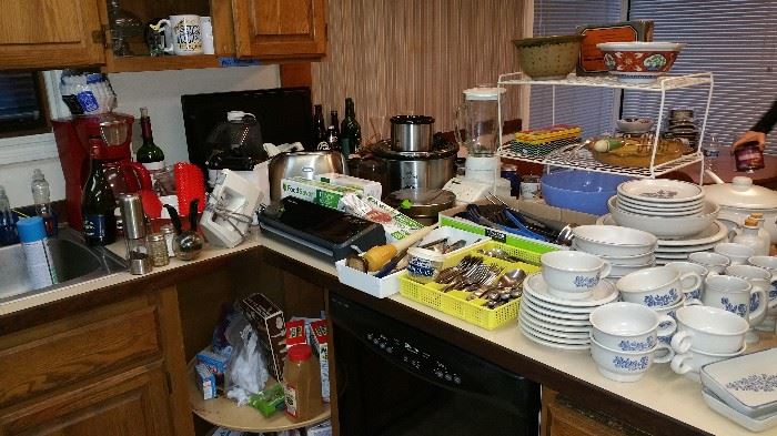 kitchen is FULL of appliances, food, dishes, utensils, pots and pans etc