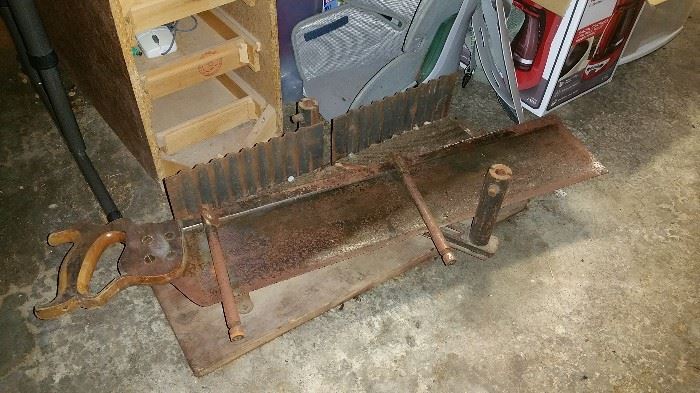 vintage hand saw and metal miter box