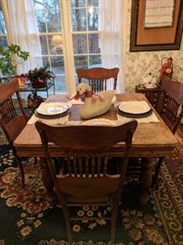 Old Farm table on wheels & 4 chairs with leather bottoms 