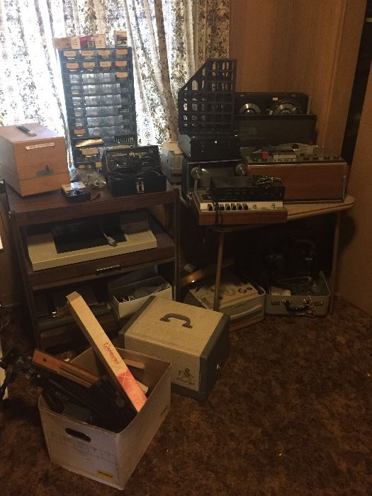 Room full of electronics reel to reels radios printers and more