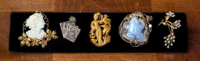 Brooches left to right cameo and 14k, CZ and sterling, tiger eye, chalceny, 14k and pearl