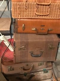 Vintage luggage and a wicker picnic hamper in the basement
