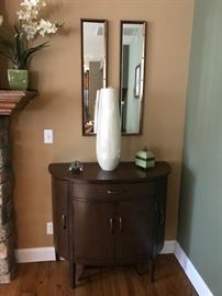 one of a pair of demilune accent cabinets
