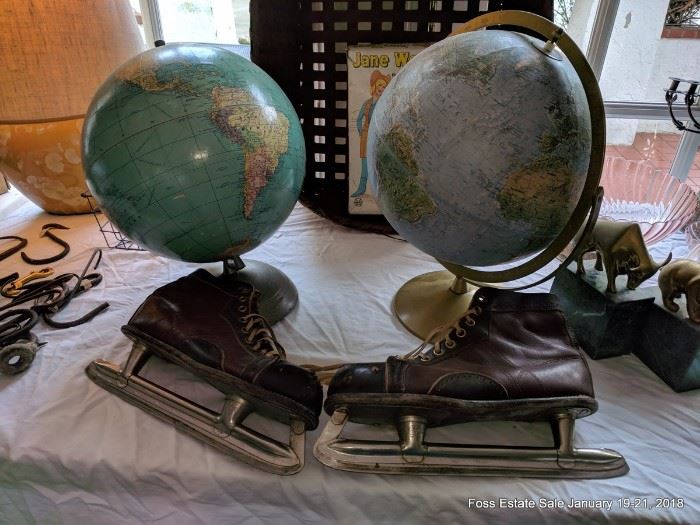 Two of several globes and a pair of vintage ice skates