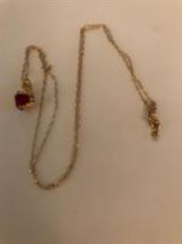 Gold necklace with a red stone