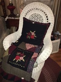 wicker rocker , and hand made quilt and pillow