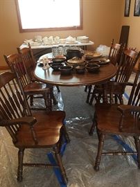 Dark wood dining room table with 4 chairs and 2 captain chairs. An extra leaf can be added to seat 8 people.