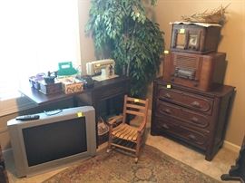 small rocker, Sears sewing machine and cabinet, antique chest of drawers, vintage radios, TV, rug