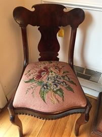 Antique 19th Century burl mahogany dining side chairs with unique carved apron.  The original seats are made of springs and horsehair.  Each chair has a handmade floral needlepoint cover, each one slightly different.  In excellent condition, set of six.