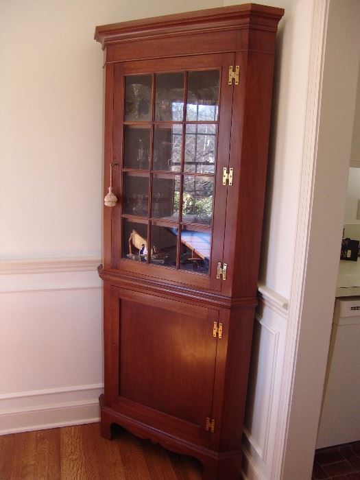 One of two mahogany corner cabinets with glass door and shelves
