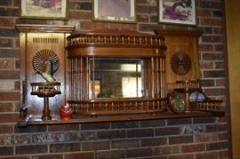 Antique Over the Mantle Center Piece of Ornately Carved Wood features a Mirrored Background surrounded by Columns and Finial Railings creating a Theater Balcony effect also with Wood Carved Pedestals on each side Accented by Carved Circular Medallions - A truly Beautiful One of a Kind work of Craftsmanship! - Gorgeous on any Fireplace Mantle or any other place. A definite stand-alone work of art!