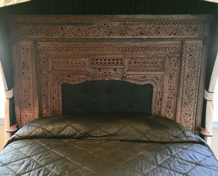 Antique hand-carved wood fireplace surround that has been converted into a king size headboard 