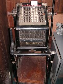 Antique Burroughs adding machine on antique stand with flip up oak shelf