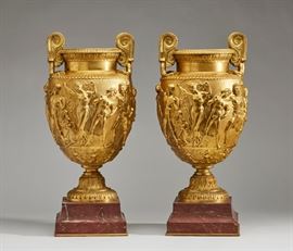 Pair of 19C Gilt Bronze Figural Neoclassical Urns      air of 19th century gilt bronze figural Bacchanalian urns. Ornate French gilt 19th century bronze urns feature allegorical scenes with classical figural decoration. Decorative and heavy urns weigh 34 pounds each. Acanthus foot mounted on stepped rouge marble bases. Good condition, miniscule chip on one corner of each marble base. Measures 20.5 inches high x 9.4 inches diameter.